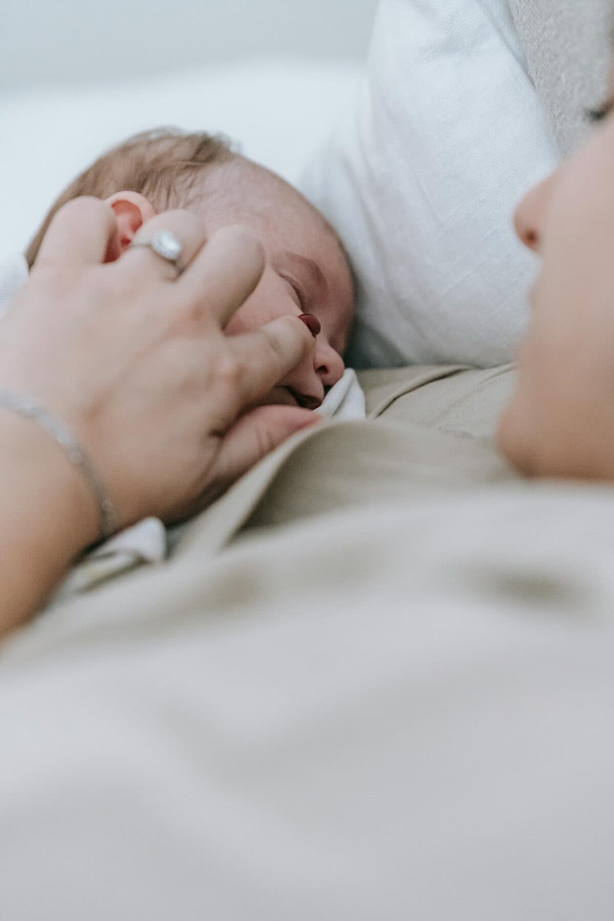 A mother lying beside her sleeping newborn