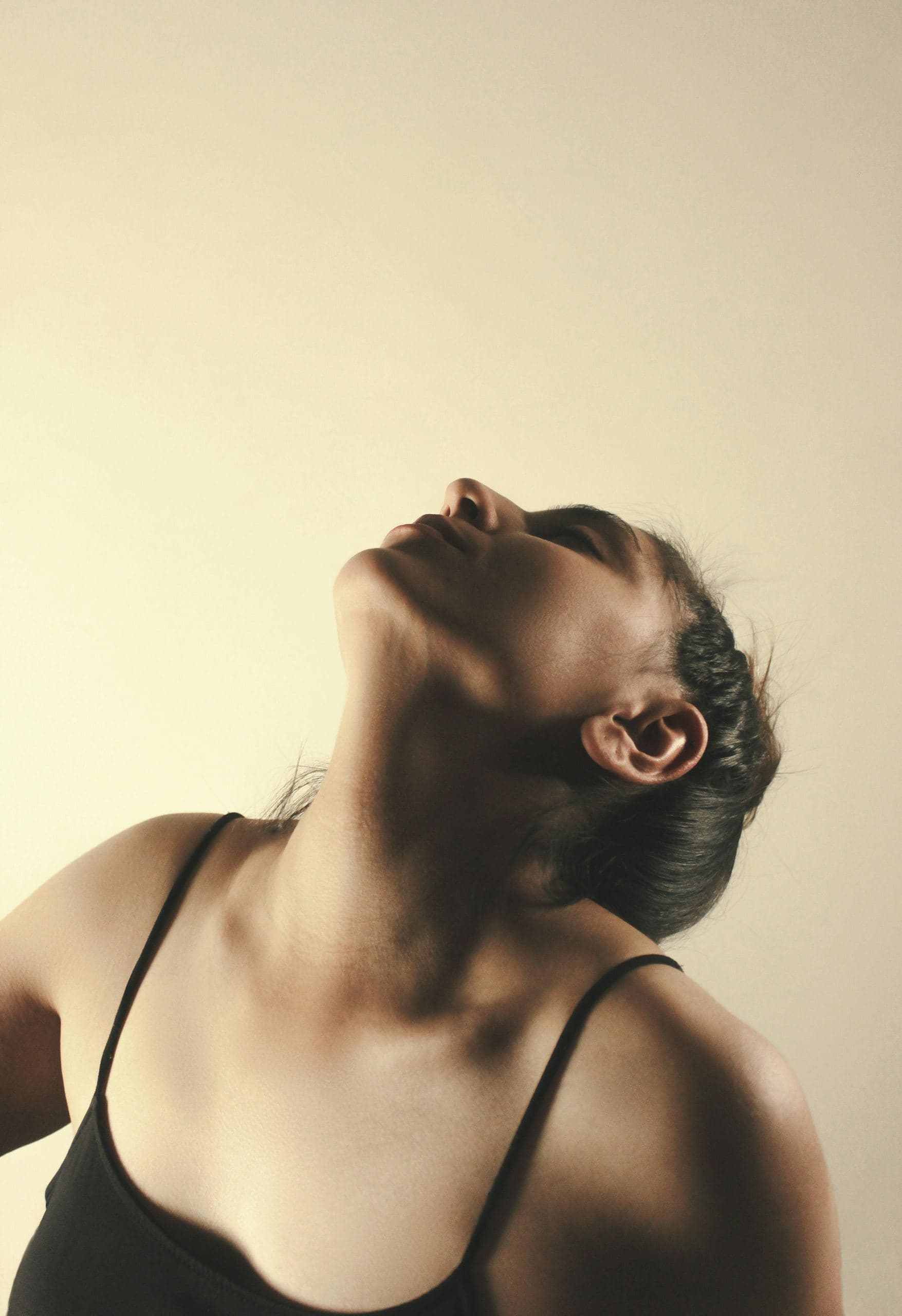 A woman with her eyes closed and her head tipped back, breathing