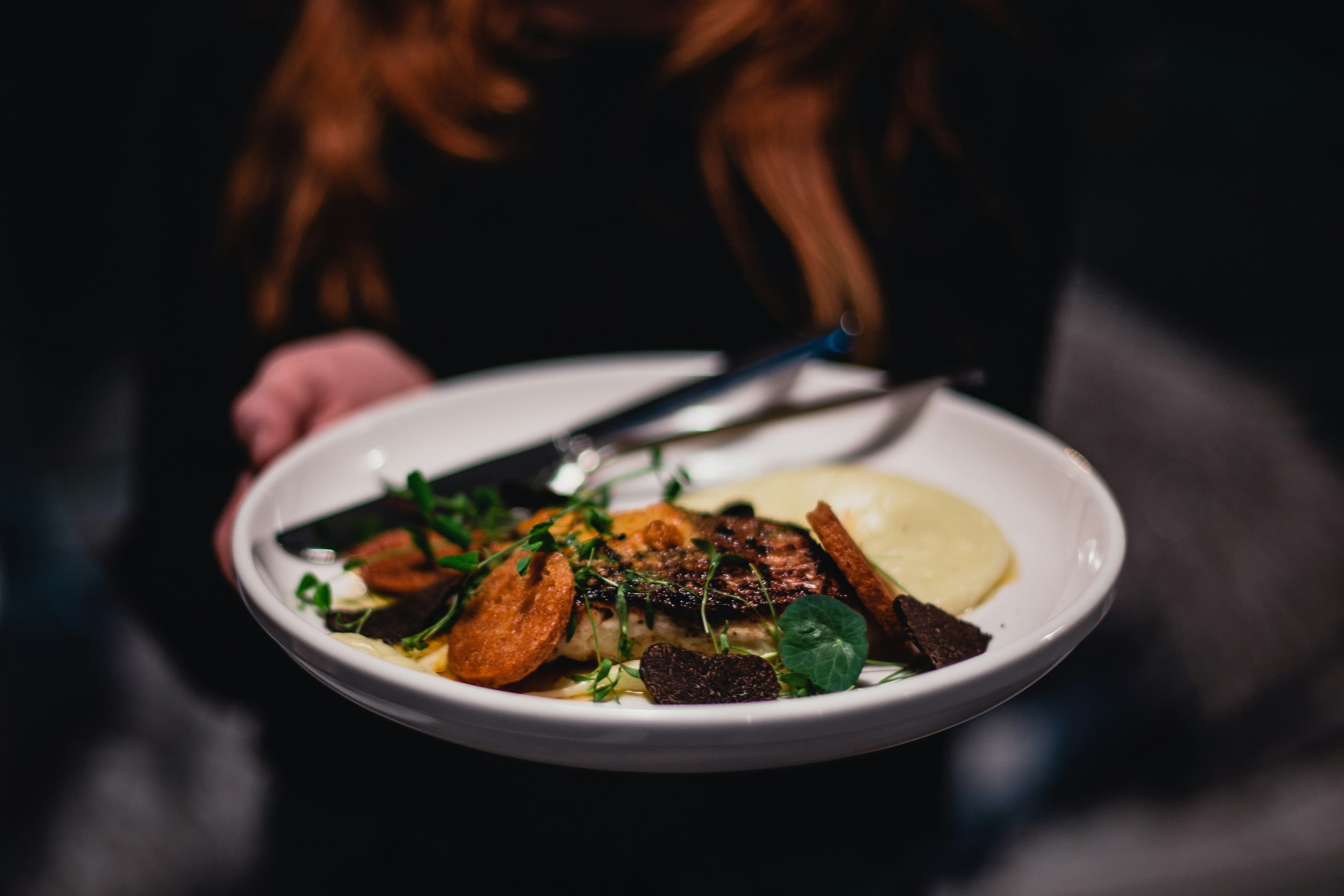 A plated postpartum main course with greens and purée