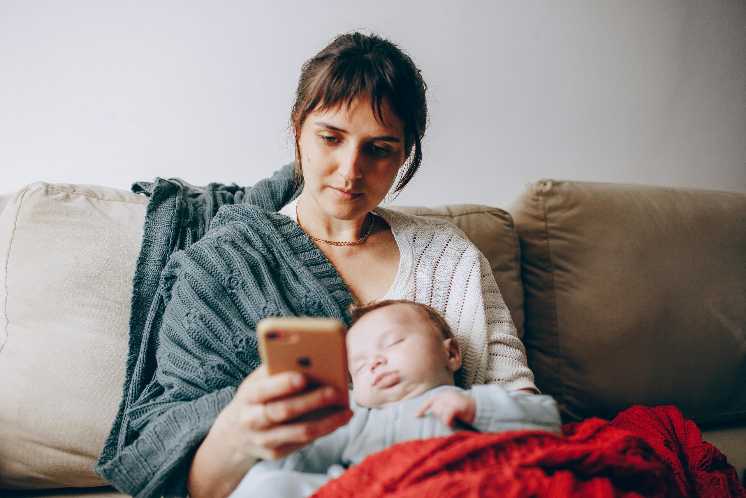 A mother on a video call with her doula while her baby sleeps